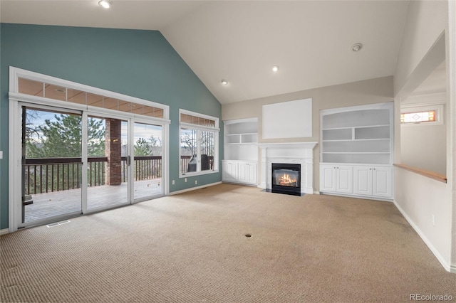 unfurnished living room featuring carpet, high vaulted ceiling, and built in features