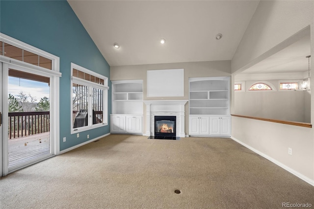 unfurnished living room featuring carpet flooring, built in shelves, and vaulted ceiling