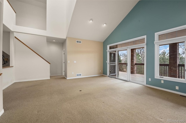 unfurnished living room with light carpet and high vaulted ceiling