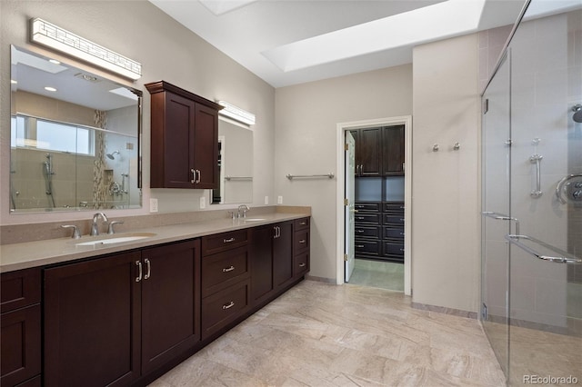 bathroom with vanity, a shower with shower door, and a skylight