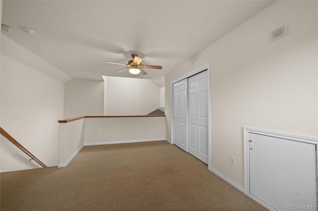 interior space featuring ceiling fan, light carpet, and lofted ceiling