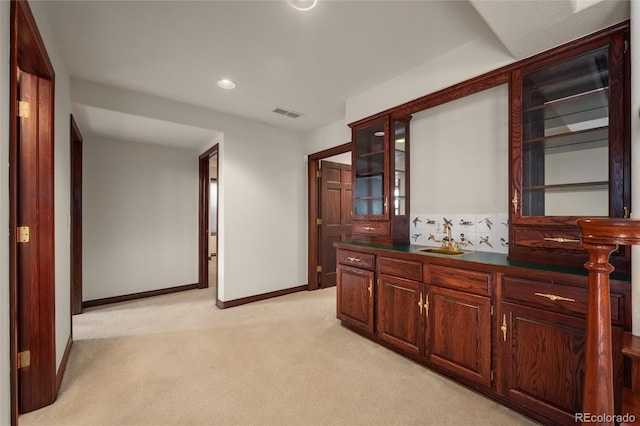 hallway featuring light carpet and sink