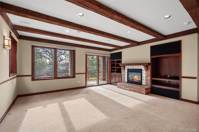 unfurnished living room with beamed ceiling, carpet floors, and a brick fireplace