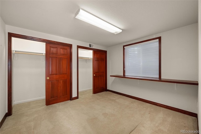 unfurnished bedroom with light colored carpet and a closet