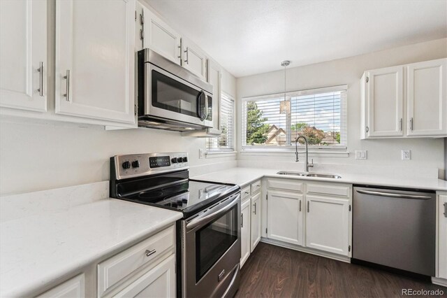 10309 W Fair Ave Unit E, Littleton, CO 80127 - kitchen featuring appliances with stainless steel finishes, a sink, white cabinets, light countertops, and dark wood finished floors