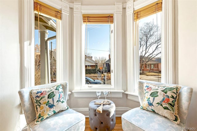 sitting room featuring a healthy amount of sunlight, baseboards, and wood finished floors