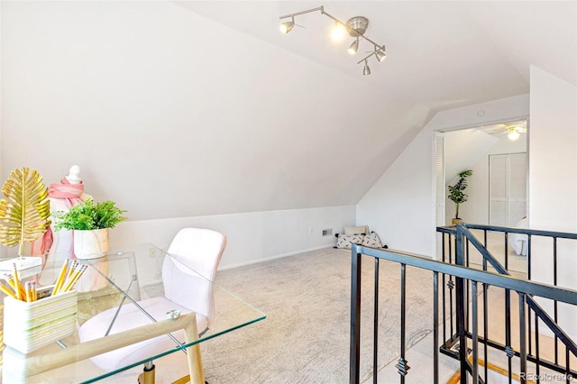 carpeted home office featuring lofted ceiling and baseboards