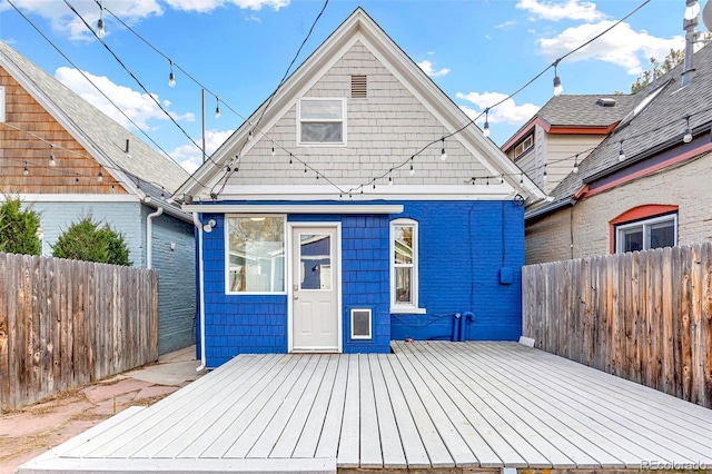 rear view of property with fence and a deck