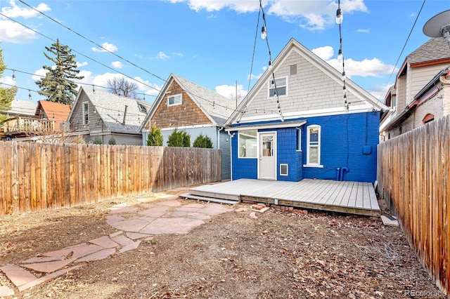 rear view of property featuring a fenced backyard and a deck