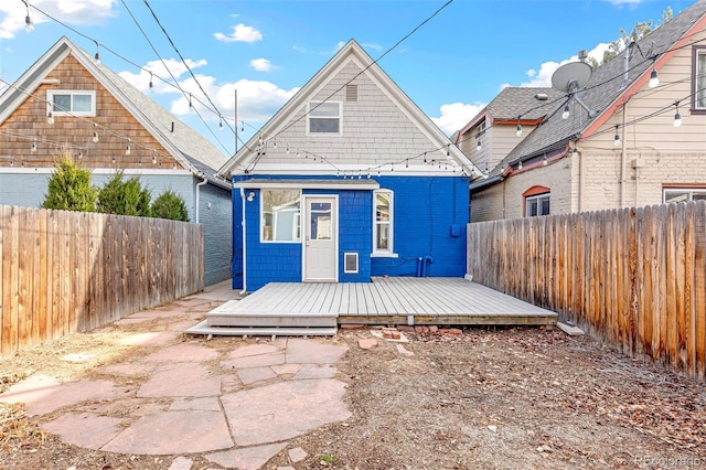 rear view of property featuring a fenced backyard and a wooden deck