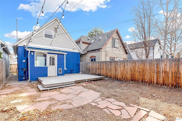 rear view of property featuring a fenced backyard and a wooden deck