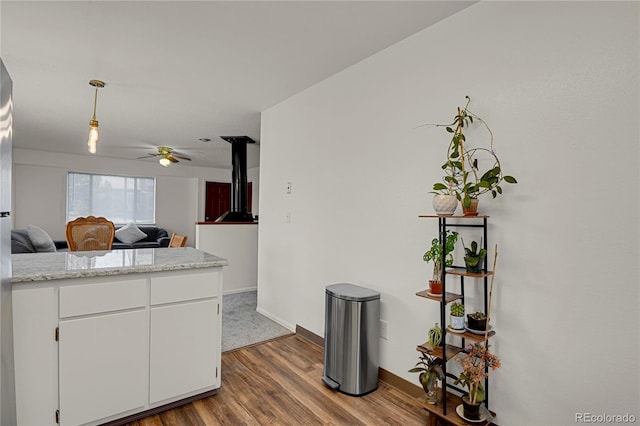 5501 Denmark Ct, Colorado Springs, CO 80918 - kitchen featuring ceiling fan, wood finished floors, white cabinetry, pendant lighting, and baseboards