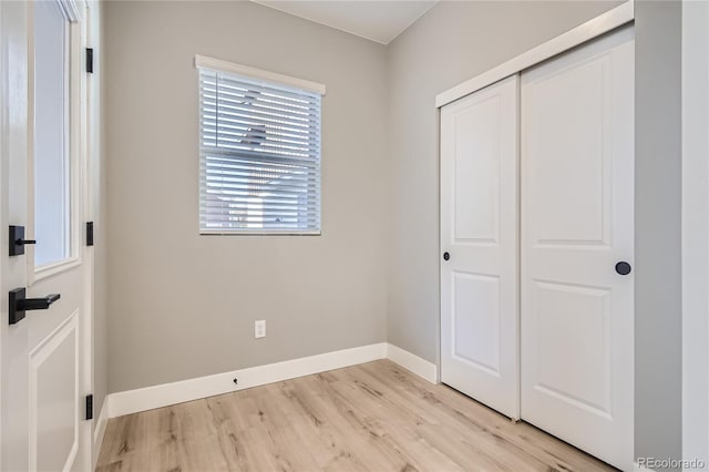 unfurnished bedroom with a closet and light wood-type flooring