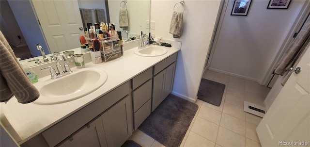 full bathroom featuring a sink, baseboards, double vanity, and tile patterned floors