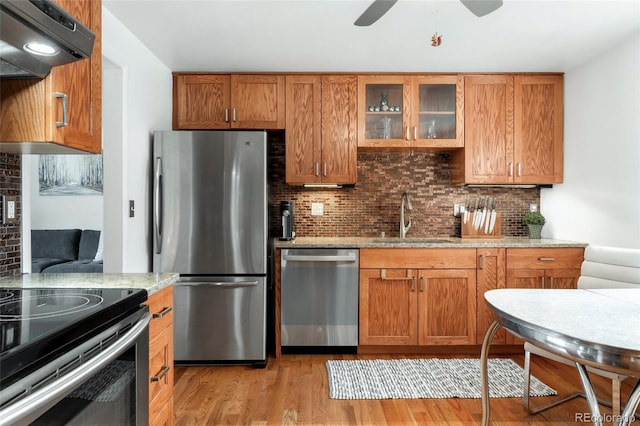 6545 Union St, Arvada, CO 80004 - kitchen with ventilation hood, tasteful backsplash, a sink, light wood finished floors, and stainless steel appliances