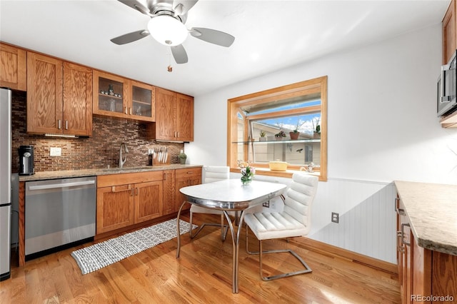 6545 Union St, Arvada, CO 80004 - kitchen with a sink, light wood-style floors, brown cabinetry, and stainless steel appliances