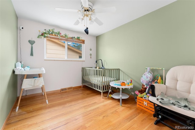 6545 Union St, Arvada, CO 80004 - bedroom with baseboards, a ceiling fan, a crib, and wood finished floors