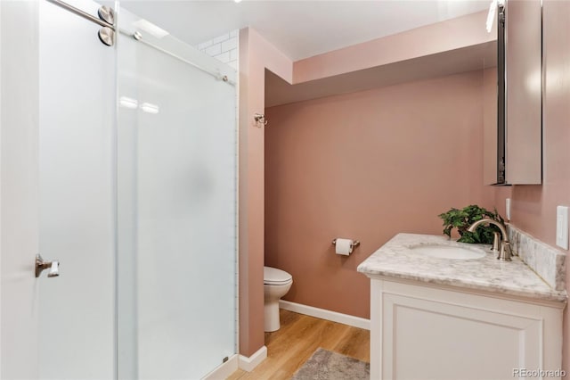 6545 Union St, Arvada, CO 80004 - bathroom with vanity, wood finished floors, toilet, baseboards, and a stall shower
