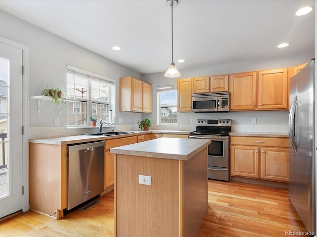 8450 E 29th Ave, Denver, CO 80238 - kitchen with stainless steel appliances, light brown cabinetry, light wood-style flooring, a center island, and recessed lighting
