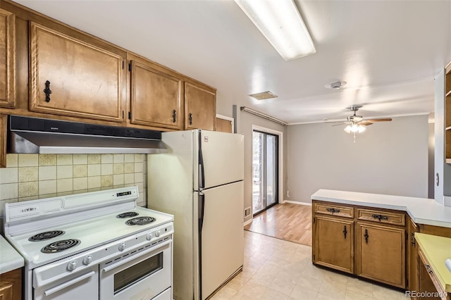 kitchen with light wood-type flooring, backsplash, ornamental molding, white appliances, and ceiling fan