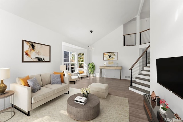 living room with hardwood / wood-style floors and high vaulted ceiling