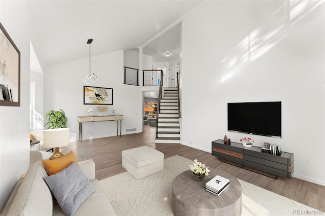 living room featuring high vaulted ceiling and hardwood / wood-style flooring