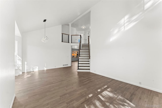 unfurnished living room with dark hardwood / wood-style flooring and high vaulted ceiling