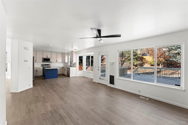 unfurnished living room with hardwood / wood-style flooring and ceiling fan