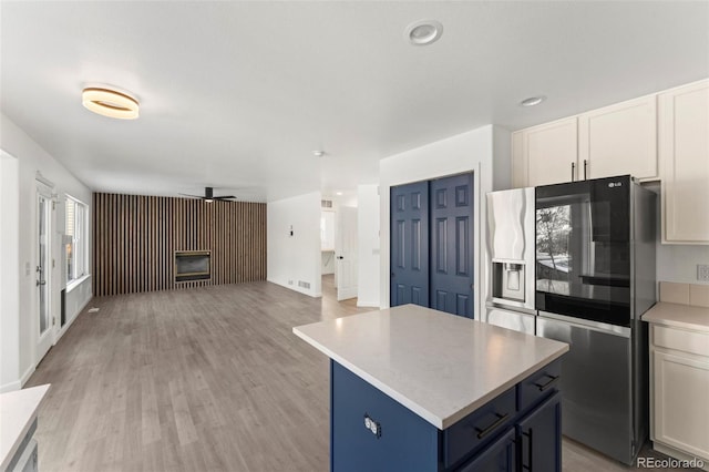 kitchen featuring stainless steel fridge with ice dispenser, a center island, white cabinets, and light hardwood / wood-style floors