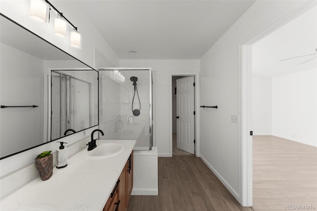 bathroom featuring hardwood / wood-style floors, vanity, ceiling fan, and an enclosed shower