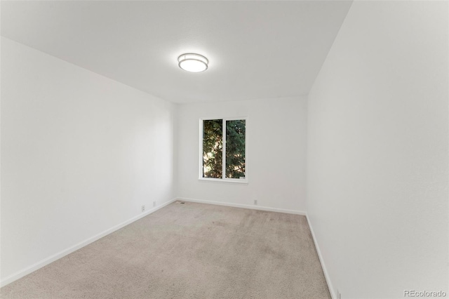 spare room featuring light carpet