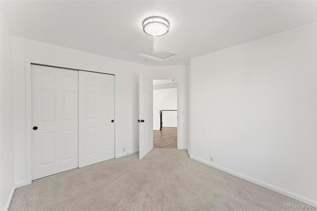 unfurnished bedroom with light carpet and a closet