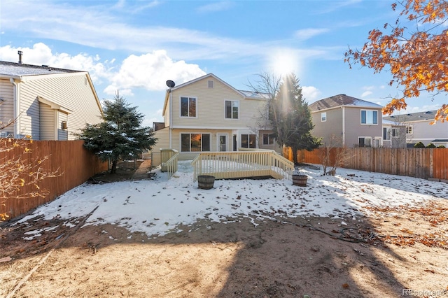 snow covered house featuring a wooden deck