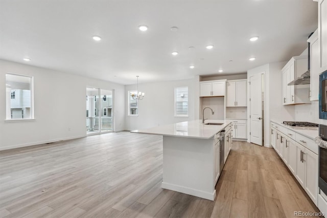 kitchen with a sink, a chandelier, recessed lighting, stainless steel gas cooktop, and light wood-style flooring
