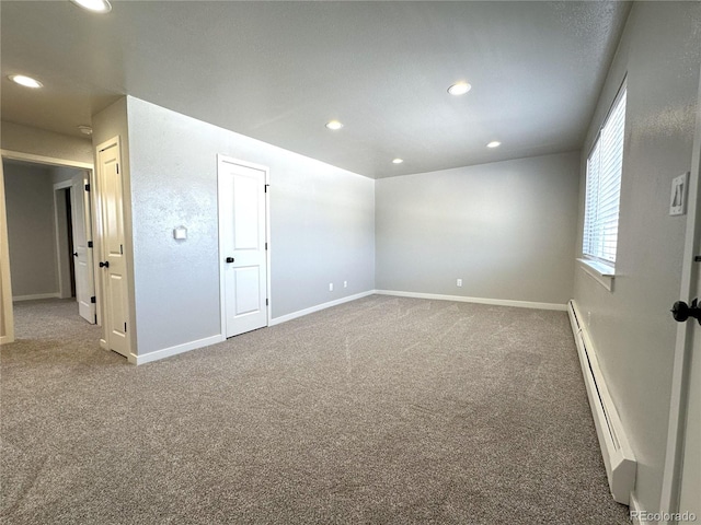 spare room featuring carpet and baseboard heating