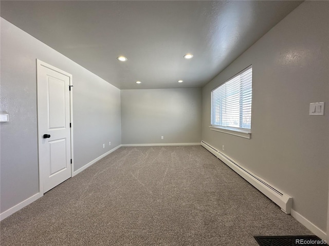 carpeted empty room with a baseboard heating unit