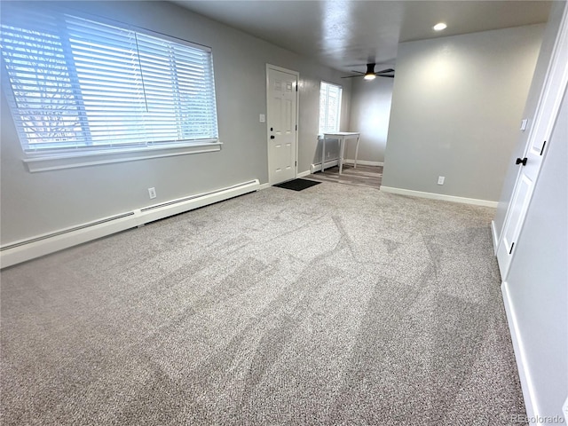 spare room with ceiling fan, carpet flooring, and baseboard heating