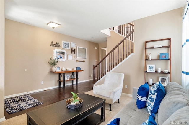 living area with stairway, baseboards, and wood finished floors