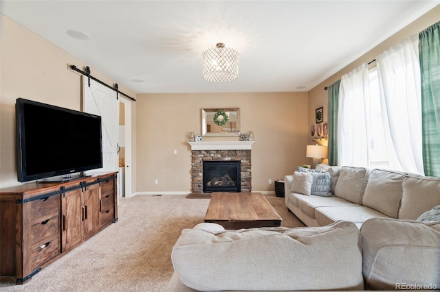 living room featuring light colored carpet, a barn door, baseboards, and a fireplace
