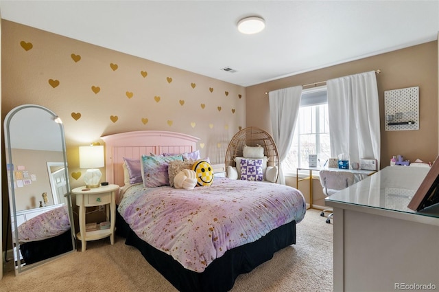 bedroom featuring wallpapered walls, light carpet, and an accent wall