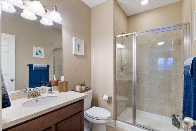 full bathroom featuring a shower stall, toilet, and vanity