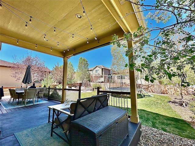 view of patio / terrace with outdoor dining space, a trampoline, and a residential view