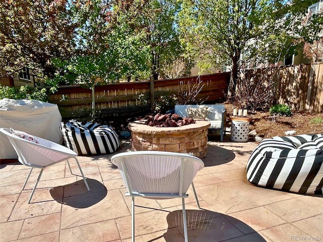 view of patio featuring a fire pit and fence