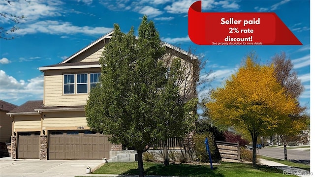 10995 Quintero St, Commerce City, CO 80022 - view of front of house with driveway, an attached garage, and stone siding