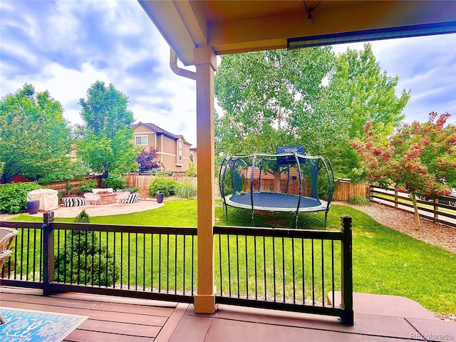 10995 Quintero St, Commerce City, CO 80022 - wooden deck featuring a trampoline, a patio area, and a fenced backyard