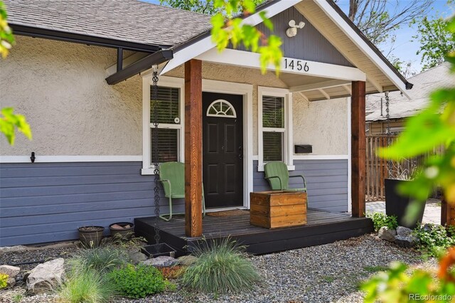 1456 Syracuse St, Denver, CO 80220 - view of exterior entry with stucco siding and a shingled roof