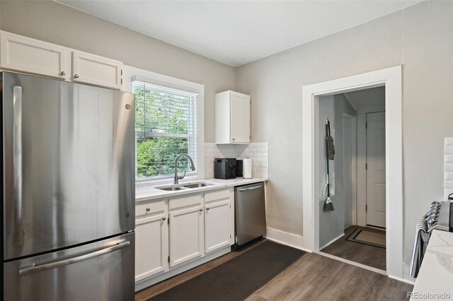 1456 Syracuse St, Denver, CO 80220 - kitchen featuring appliances with stainless steel finishes, a sink, dark wood-style floors, light countertops, and white cabinetry