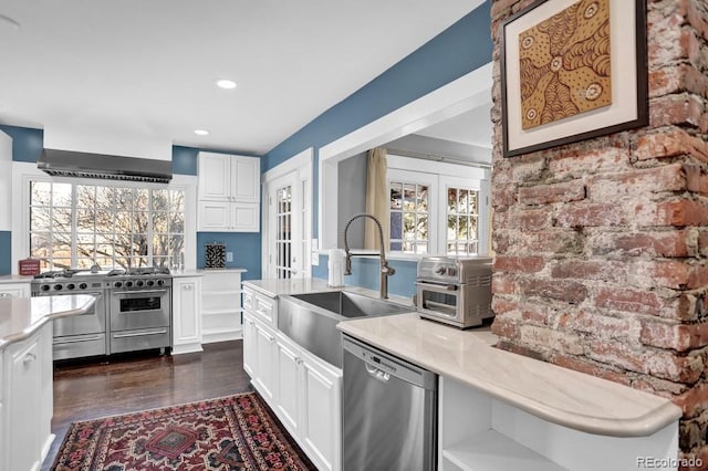 5725 W Mississippi Ave, Lakewood, CO 80226 - kitchen with stainless steel appliances, a sink, french doors, wall chimney range hood, and white cabinetry