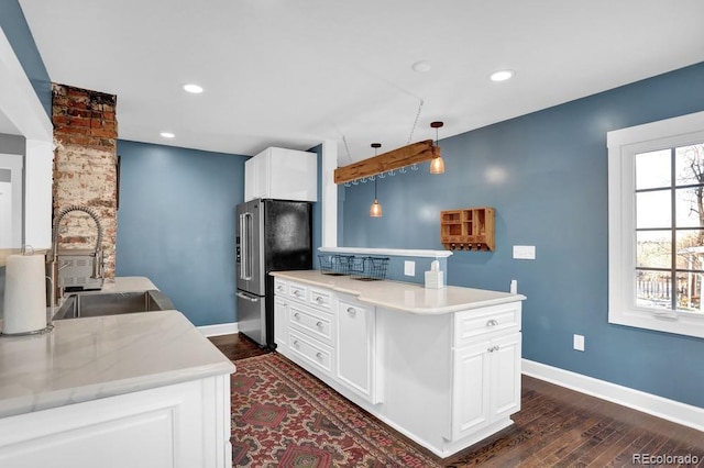 5725 W Mississippi Ave, Lakewood, CO 80226 - kitchen featuring high end fridge, a sink, dark wood-style floors, a peninsula, and baseboards