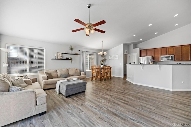 living room featuring ceiling fan with notable chandelier, high vaulted ceiling, and hardwood / wood-style flooring